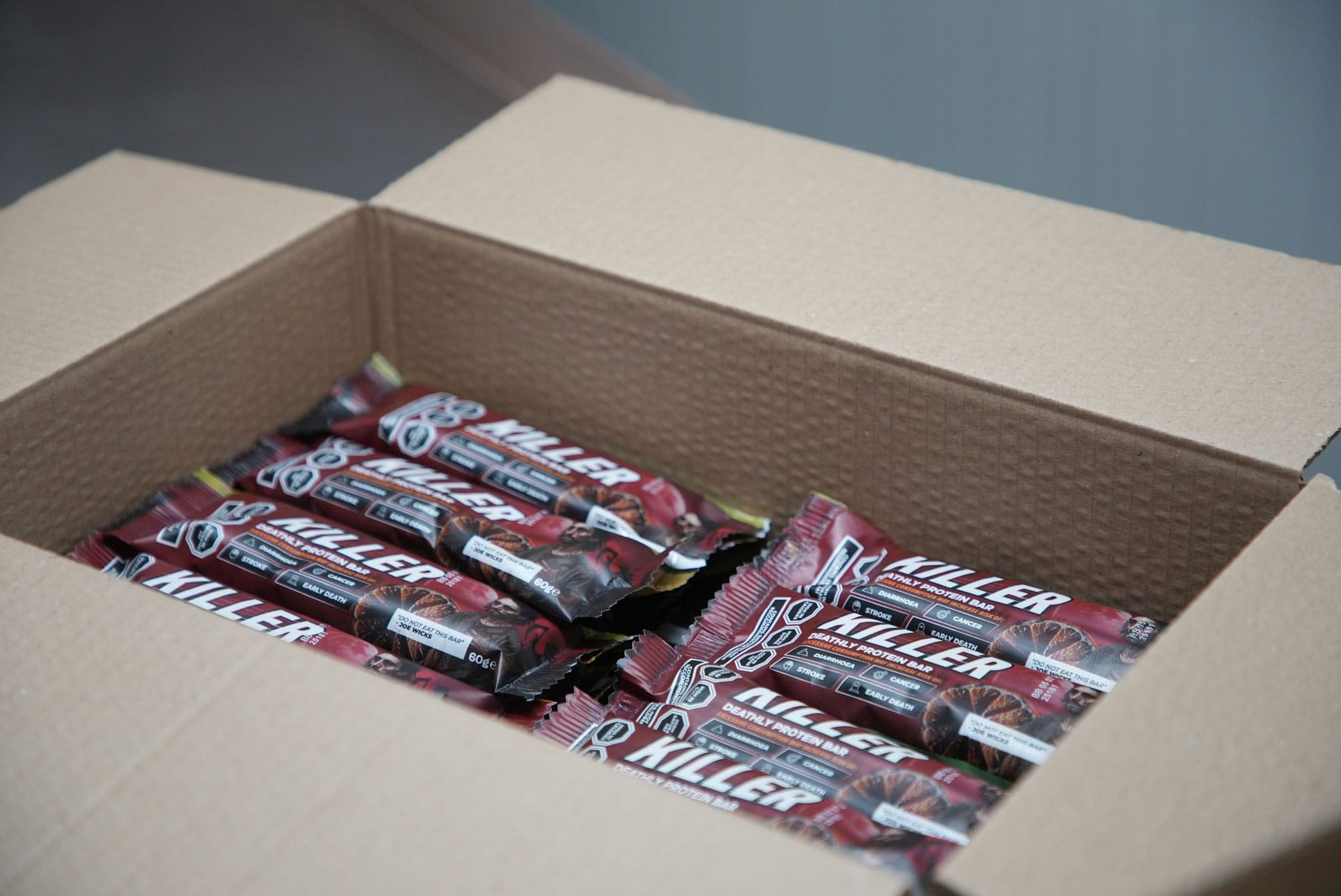 Printed Killer Bar packaging being prepared in a box, showing the finished product as a convincing real-world object